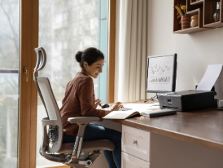 woman behind desk working on a computer