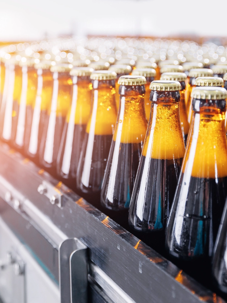 filled bottles lined up at a factory